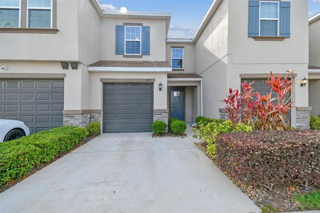 6825 Citrus Creek Ln, Tampa, FL 33625 - townhome / multi-family property featuring an attached garage, stone siding, stucco siding, and driveway