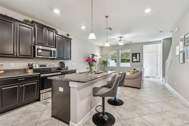 6825 Citrus Creek Ln, Tampa, FL 33625 - kitchen featuring appliances with stainless steel finishes, open floor plan, light tile patterned flooring, a breakfast bar area, and recessed lighting