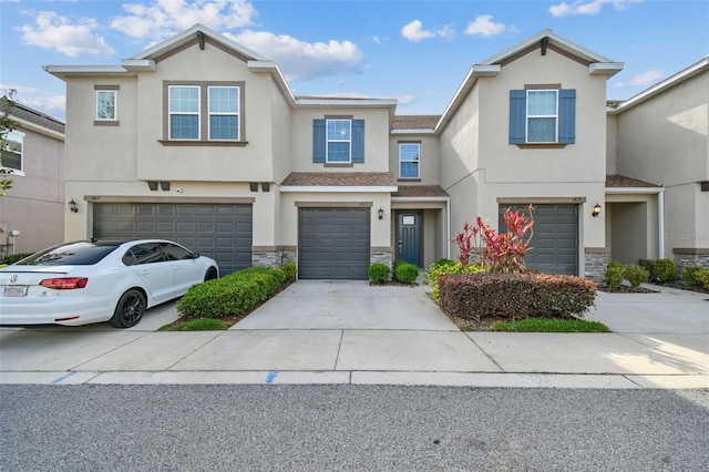 6825 Citrus Creek Ln, Tampa, FL 33625 - townhome / multi-family property with an attached garage, stone siding, stucco siding, and driveway