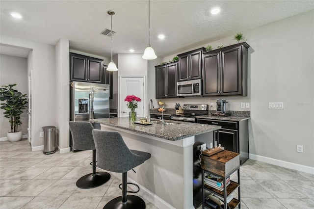 6825 Citrus Creek Ln, Tampa, FL 33625 - kitchen with appliances with stainless steel finishes, a kitchen breakfast bar, recessed lighting, an island with sink, and stone countertops