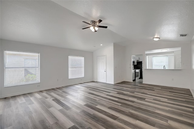 4129 Marlow Loop, Land O Lakes, FL 34639 - unfurnished living room featuring vaulted ceiling, a ceiling fan, wood finished floors, and a textured ceiling