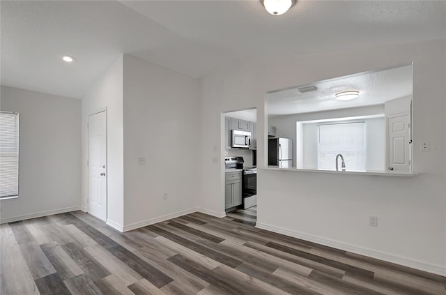 4129 Marlow Loop, Land O Lakes, FL 34639 - kitchen featuring appliances with stainless steel finishes, dark wood-style flooring, lofted ceiling, light countertops, and recessed lighting
