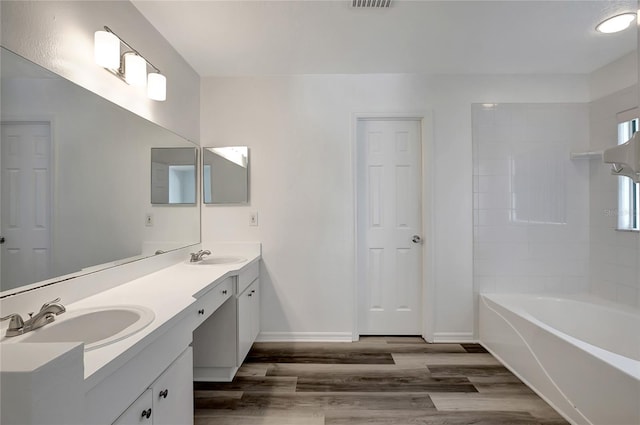4129 Marlow Loop, Land O Lakes, FL 34639 - full bathroom with wood finished floors, double vanity, and washtub / shower combination