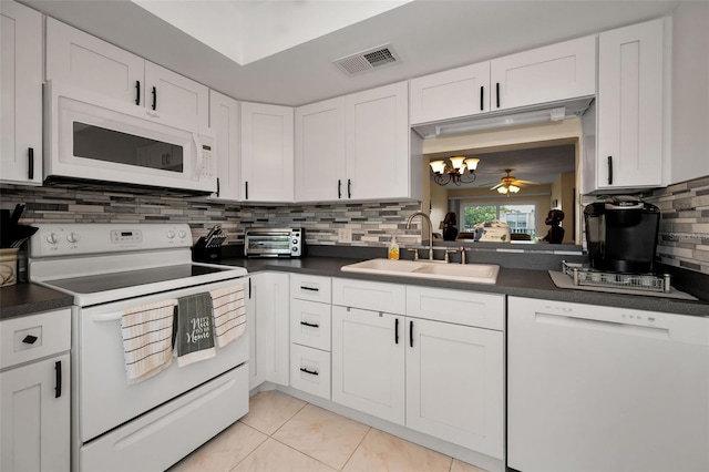 960 Virginia St Unit 204, Dunedin, FL 34698 - kitchen featuring white appliances, dark countertops, tasteful backsplash, a chandelier, and white cabinetry