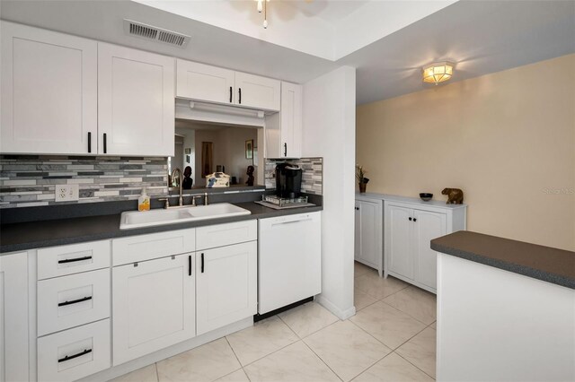 960 Virginia St Unit 204, Dunedin, FL 34698 - kitchen with dishwasher, dark countertops, decorative backsplash, white cabinets, and light tile patterned flooring