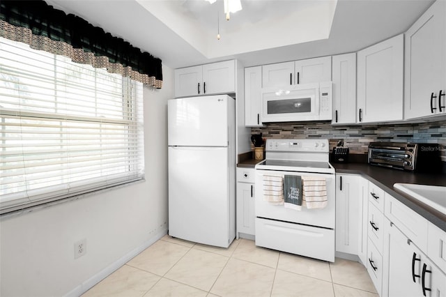 960 Virginia St Unit 204, Dunedin, FL 34698 - kitchen with white appliances, healthy amount of natural light, dark countertops, and decorative backsplash