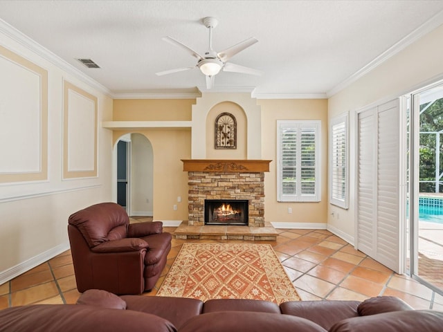 18803 Misty Shores Ln, Lutz, FL 33548 - living room featuring light tile patterned flooring, ornamental molding, ceiling fan, arched walkways, and a stone fireplace