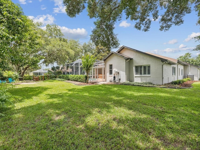 18803 Misty Shores Ln, Lutz, FL 33548 - rear view of property featuring stucco siding, a yard, and glass enclosure