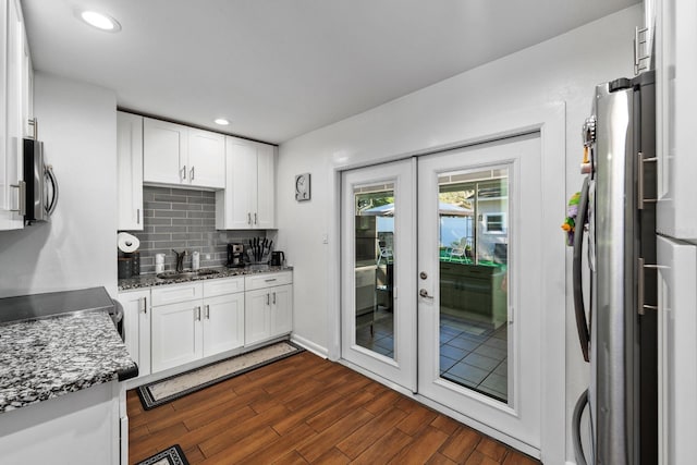 7003 Yule Ln, Tampa, FL 33637 - kitchen featuring appliances with stainless steel finishes, french doors, white cabinets, dark wood-style floors, and backsplash