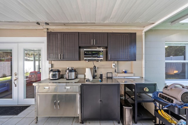 7003 Yule Ln, Tampa, FL 33637 - kitchen with stainless steel countertops, french doors, light tile patterned floors, and healthy amount of natural light