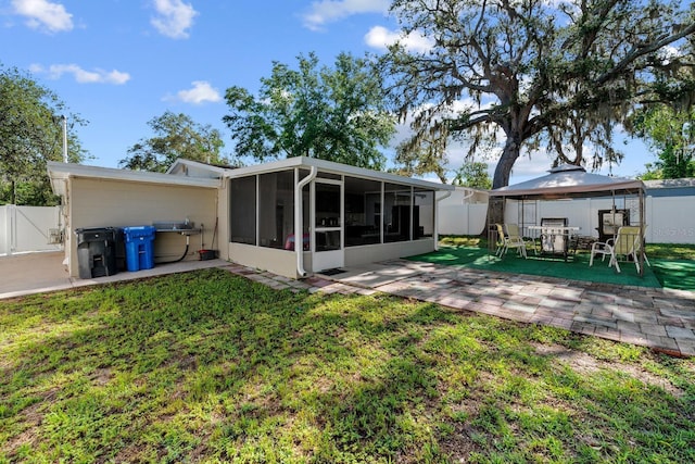 7003 Yule Ln, Tampa, FL 33637 - back of property featuring a sunroom, a gazebo, a patio area, and a fenced backyard