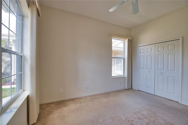 8354 Palmetto Ct, Englewood, FL 34224 - unfurnished bedroom with light carpet, multiple windows, ceiling fan, and a closet