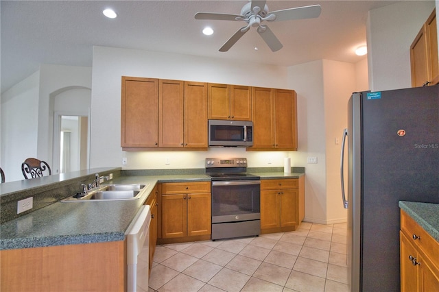 8354 Palmetto Ct, Englewood, FL 34224 - kitchen with stainless steel appliances, ceiling fan, light tile patterned floors, recessed lighting, and brown cabinetry