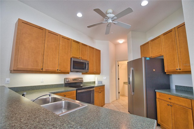 8354 Palmetto Ct, Englewood, FL 34224 - kitchen featuring appliances with stainless steel finishes, ceiling fan, dark countertops, light tile patterned flooring, and brown cabinets