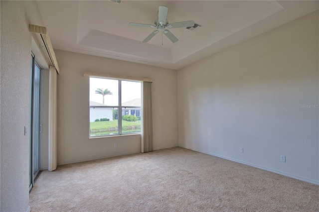8354 Palmetto Ct, Englewood, FL 34224 - empty room featuring light carpet, ceiling fan, and a tray ceiling