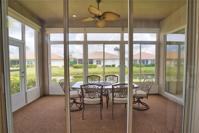 8354 Palmetto Ct, Englewood, FL 34224 - sunroom / solarium with carpet flooring, a water view, a ceiling fan, a textured ceiling, and a residential view