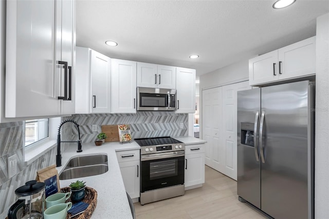 8045 Colton Dr, Port Richey, FL 34668 - kitchen with appliances with stainless steel finishes, white cabinets, backsplash, light wood finished floors, and recessed lighting