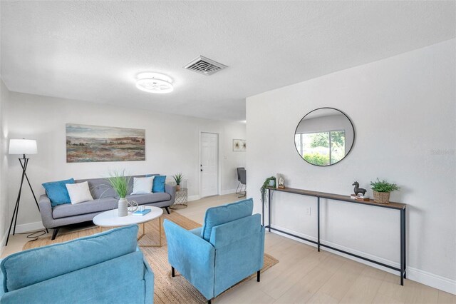 8045 Colton Dr, Port Richey, FL 34668 - living area with light wood-style floors and a textured ceiling