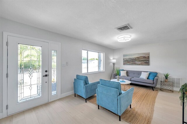8045 Colton Dr, Port Richey, FL 34668 - living area with light wood finished floors and a textured ceiling