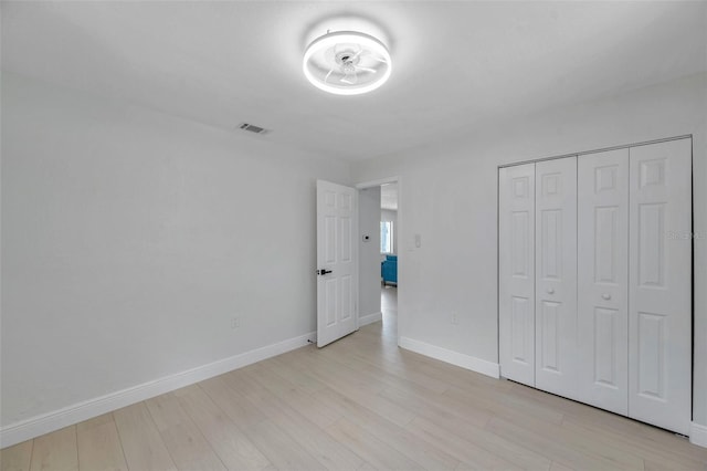 8045 Colton Dr, Port Richey, FL 34668 - unfurnished bedroom with light wood-style flooring and a closet