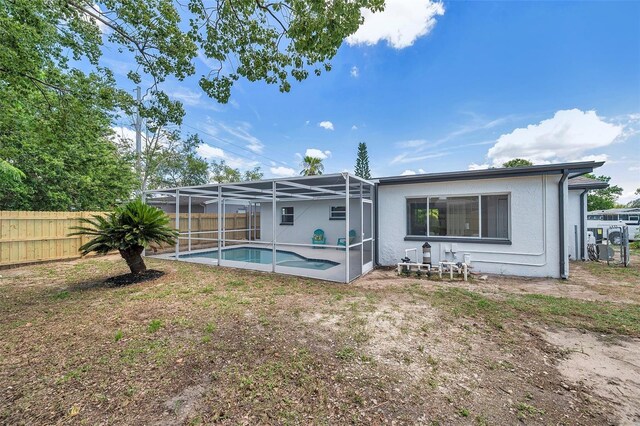 8045 Colton Dr, Port Richey, FL 34668 - rear view of property with a fenced backyard, a lanai, and stucco siding