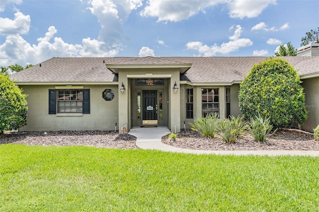 2925 Deerbrook Dr, Lakeland, FL 33811 - view of front of home featuring a shingled roof, a front yard, and stucco siding