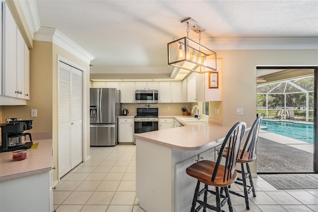 2925 Deerbrook Dr, Lakeland, FL 33811 - kitchen featuring stainless steel appliances, crown molding, light tile patterned floors, a peninsula, and light countertops