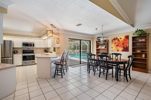 2925 Deerbrook Dr, Lakeland, FL 33811 - kitchen with appliances with stainless steel finishes, light tile patterned flooring, light countertops, white cabinetry, and crown molding