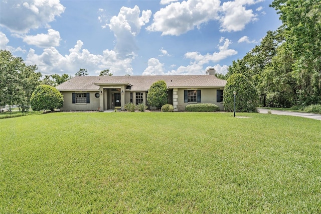 2925 Deerbrook Dr, Lakeland, FL 33811 - single story home with stucco siding, a front lawn, a chimney, and roof with shingles