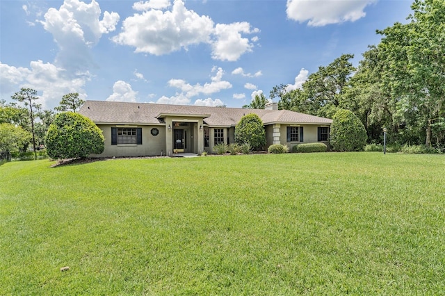 2925 Deerbrook Dr, Lakeland, FL 33811 - single story home featuring a front lawn, stucco siding, a shingled roof, and a chimney