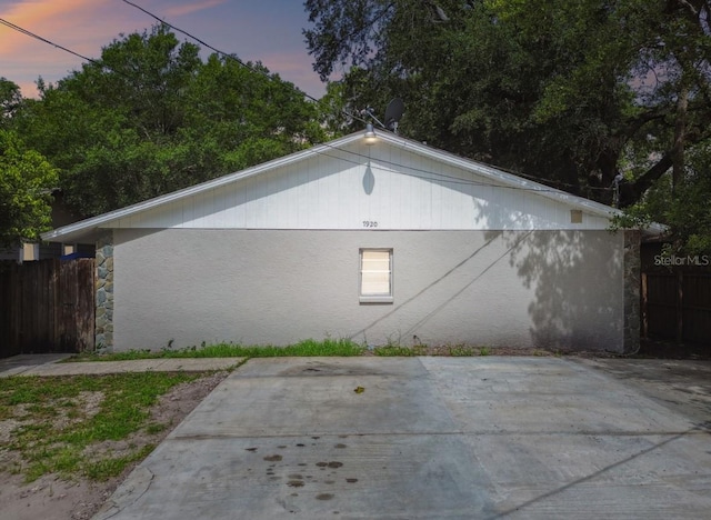 7920 N Marks St, Tampa, FL 33604 - property exterior at dusk featuring a patio area and stone siding
