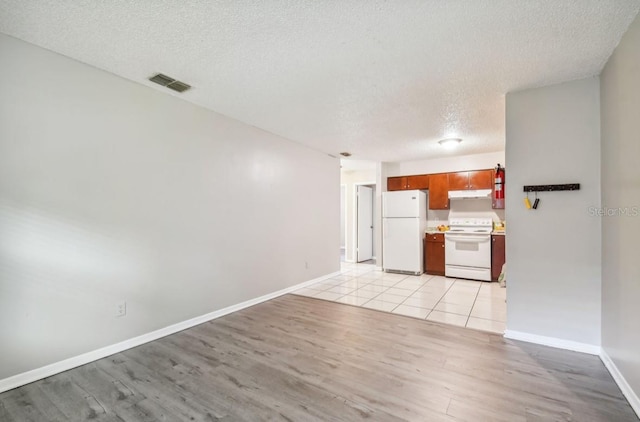 7920 N Marks St, Tampa, FL 33604 - unfurnished living room with light wood-type flooring and a textured ceiling