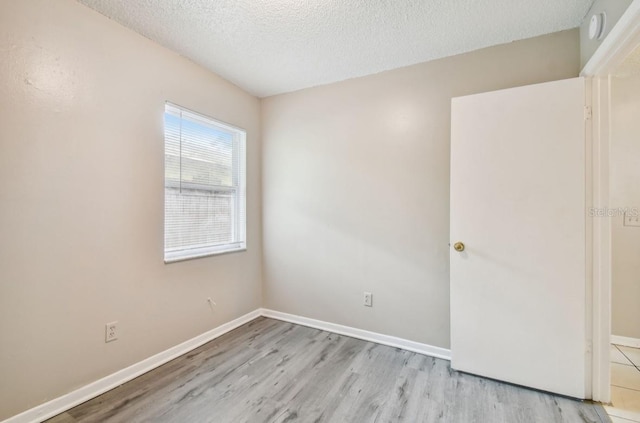 7920 N Marks St, Tampa, FL 33604 - empty room with a textured ceiling, light wood finished floors, and a smoke detector