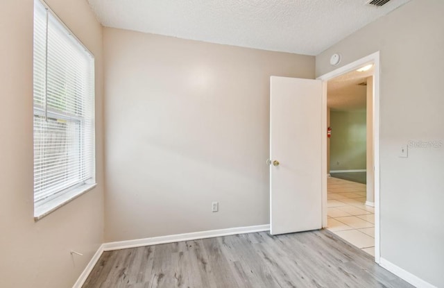 7920 N Marks St, Tampa, FL 33604 - unfurnished room with wood finished floors, a smoke detector, and a textured ceiling