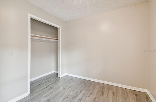 7920 N Marks St, Tampa, FL 33604 - unfurnished bedroom with wood finished floors, a closet, and a textured ceiling