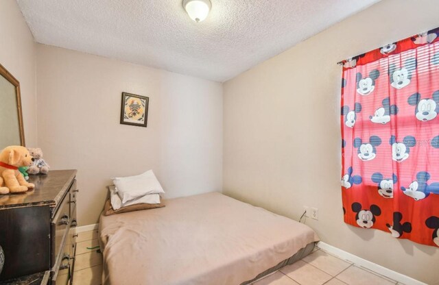7920 N Marks St, Tampa, FL 33604 - tiled bedroom with a textured ceiling and baseboards