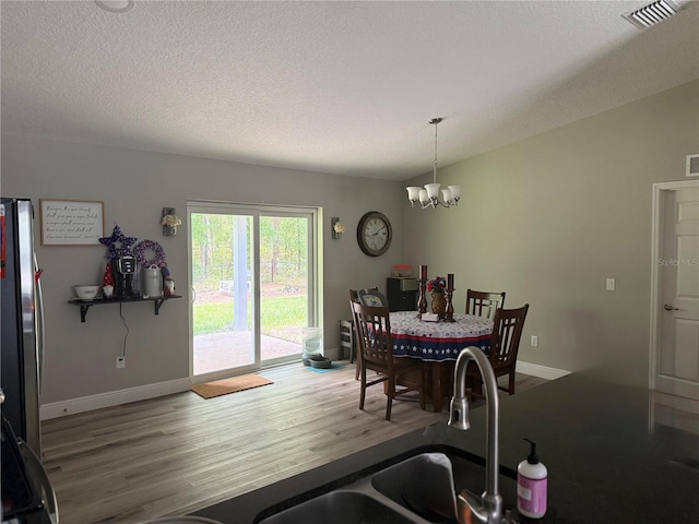 8737 N Spikes Way, Dunnellon, FL 34434 - dining space with a chandelier, wood finished floors, and a textured ceiling