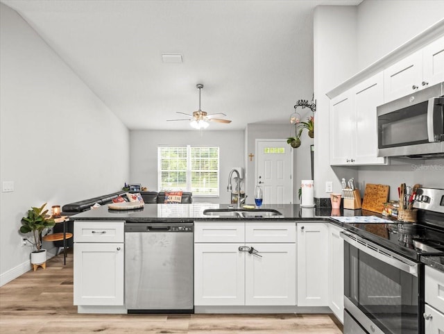 8737 N Spikes Way, Dunnellon, FL 34434 - kitchen featuring stainless steel appliances, a peninsula, white cabinetry, light wood-style floors, and ceiling fan