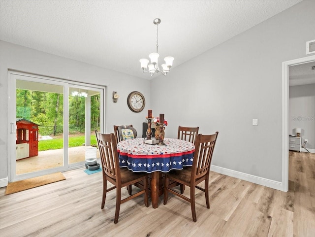 8737 N Spikes Way, Dunnellon, FL 34434 - dining space with light wood-style floors, a chandelier, and a textured ceiling