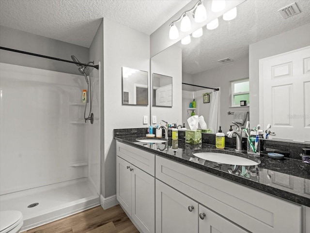 8737 N Spikes Way, Dunnellon, FL 34434 - bathroom with a shower with shower curtain, wood finished floors, double vanity, and a textured ceiling