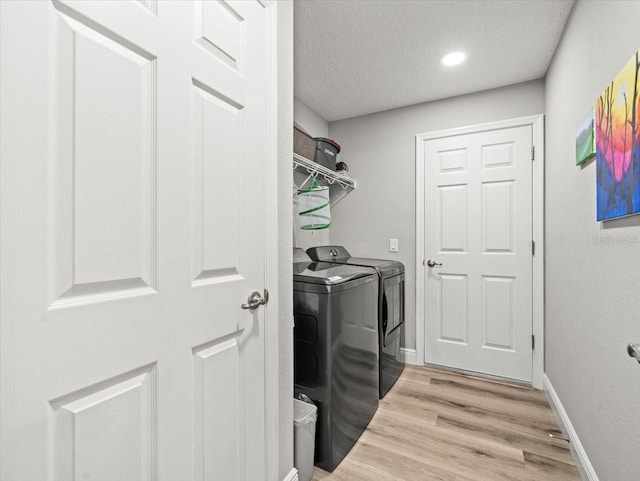 8737 N Spikes Way, Dunnellon, FL 34434 - washroom featuring separate washer and dryer, light wood-type flooring, and a textured ceiling