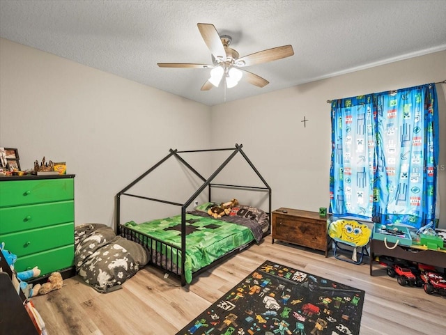 8737 N Spikes Way, Dunnellon, FL 34434 - bedroom featuring wood finished floors, a textured ceiling, and a ceiling fan