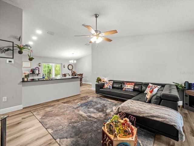 8737 N Spikes Way, Dunnellon, FL 34434 - living room featuring wood finished floors, a ceiling fan, a chandelier, and a textured ceiling
