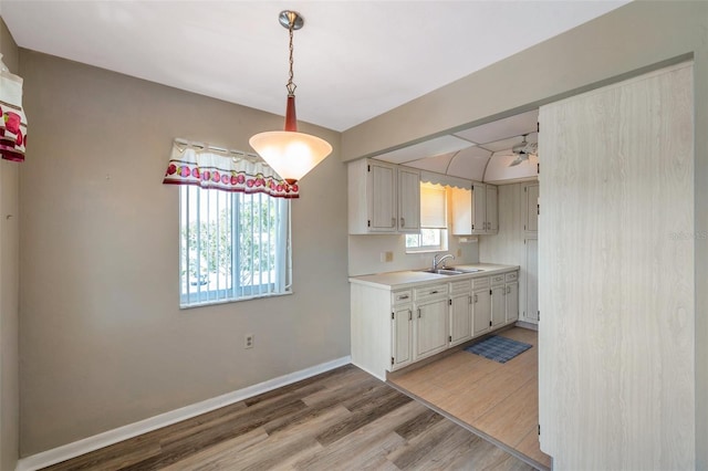 8396 111th St Unit 301, Seminole, FL 33772 - kitchen featuring light wood-style floors, light countertops, white cabinetry, and hanging light fixtures