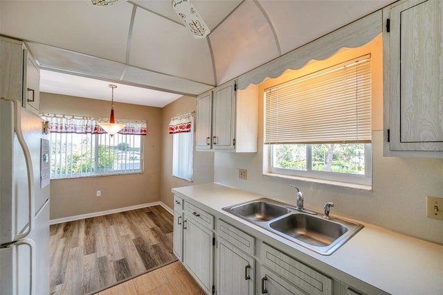 8396 111th St Unit 301, Seminole, FL 33772 - kitchen featuring freestanding refrigerator, light wood-type flooring, plenty of natural light, and light countertops