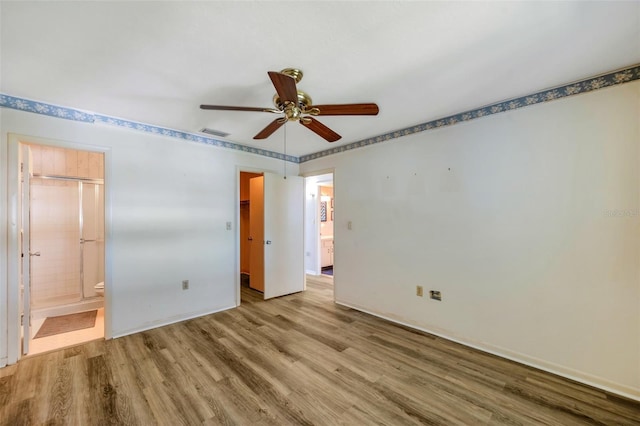 8396 111th St Unit 301, Seminole, FL 33772 - unfurnished bedroom featuring wood finished floors, connected bathroom, and a ceiling fan