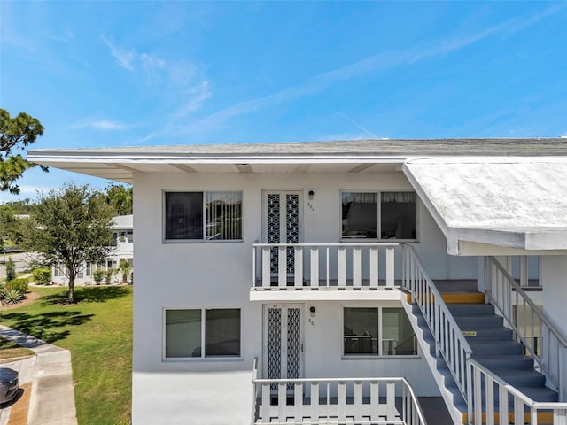 8396 111th St Unit 301, Seminole, FL 33772 - rear view of house with stairway, stucco siding, and a yard