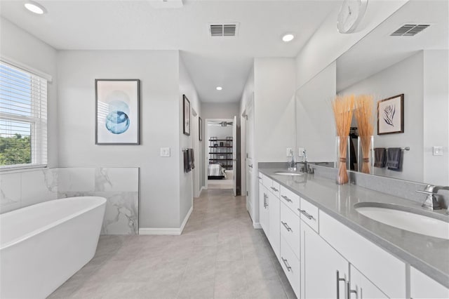 8050 Praise Dr, Tampa, FL 33625 - bathroom with a freestanding bath, double vanity, recessed lighting, and tile patterned floors
