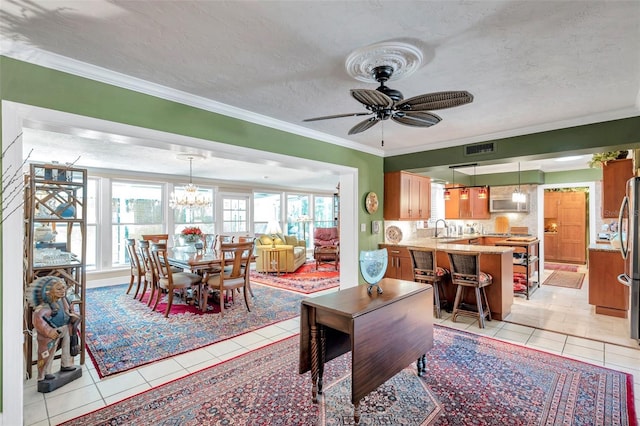 3898 49th Ave S, Saint Petersburg, FL 33711 - dining room featuring light tile patterned floors, a chandelier, a ceiling fan, crown molding, and a textured ceiling