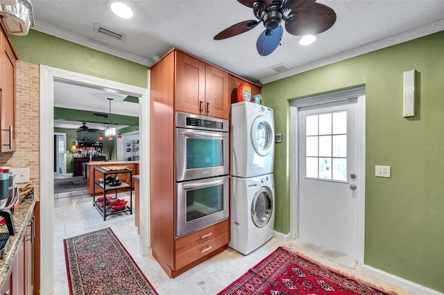 3898 49th Ave S, Saint Petersburg, FL 33711 - laundry area featuring a ceiling fan, stacked washer / dryer, and ornamental molding